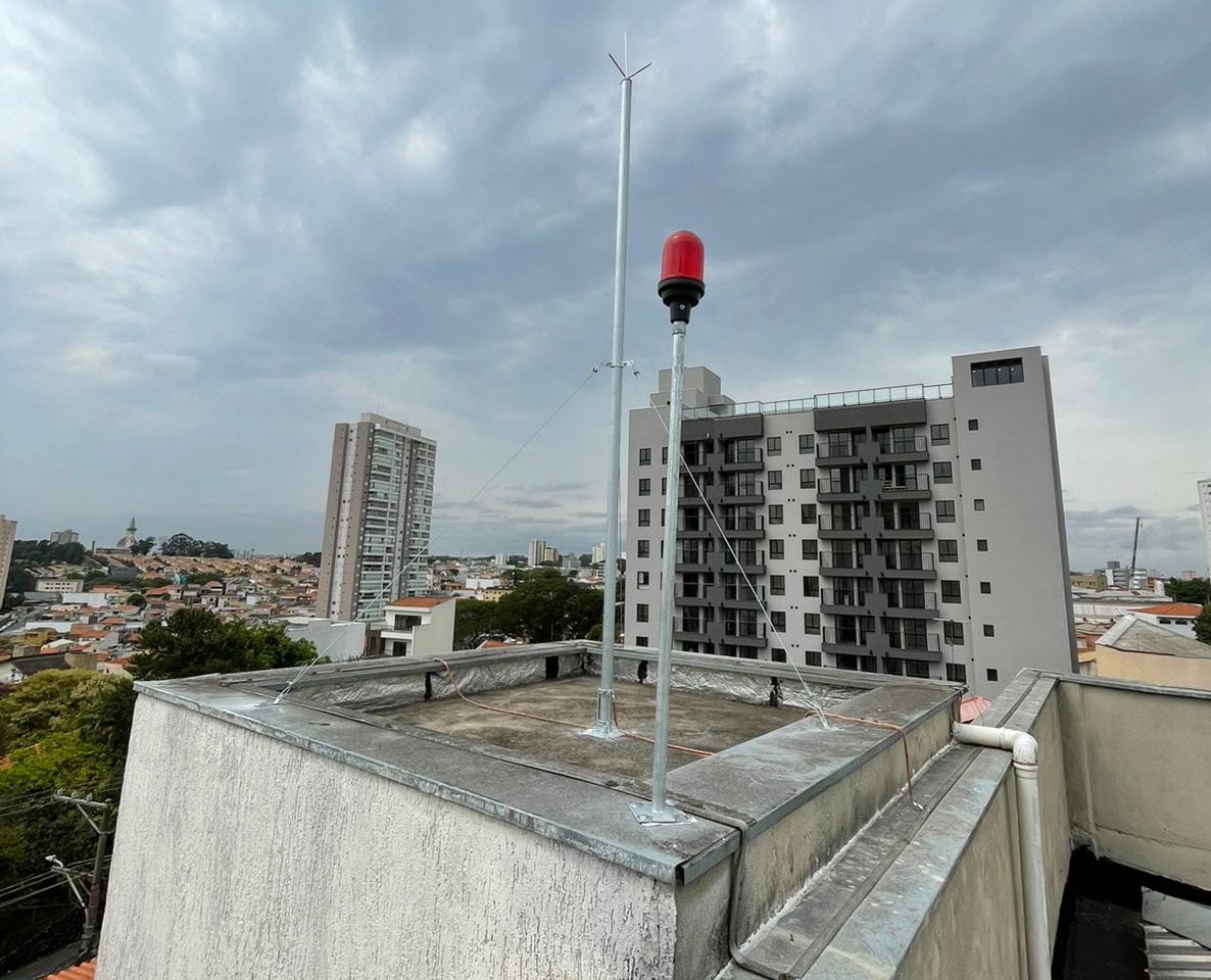 Equipe técnica executando a instalação de sistema de para-raios (SPDA) com segurança e engenharia certificada